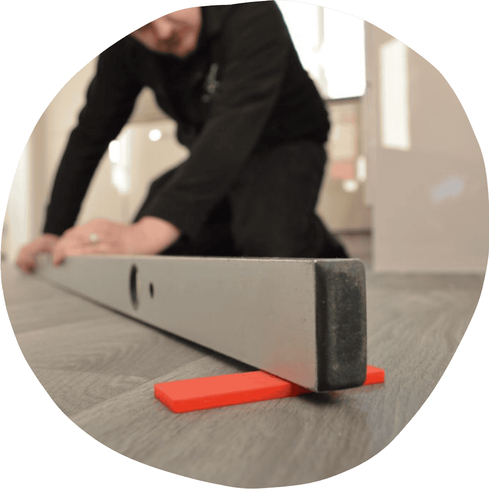 A surveyor holding a spirit level on an un level floor